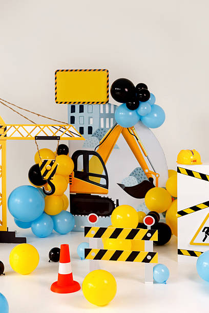 istock Playful construction zone decoration featuring toy excavator cutout, crane hook, striped barricade 2232756099