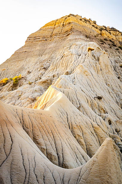 A dramatic sunset casts a golden glow over the unique hills and badlands formations of Makoshika State Park