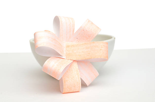 Orange ribbon isolated on a pink background.