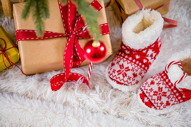 istock Christmas Gift Boxes and Cozy Baby Booties Under the Tree 2232760260