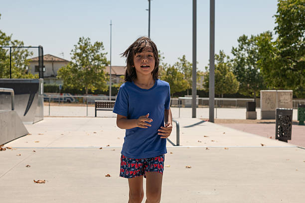 Happy child running in a skate park during a sunny summer day