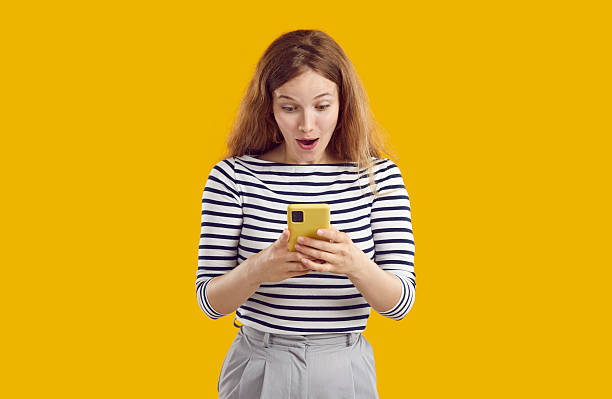 istock Young woman looking at her mobile phone with happy excited surprised face expression 2232763507
