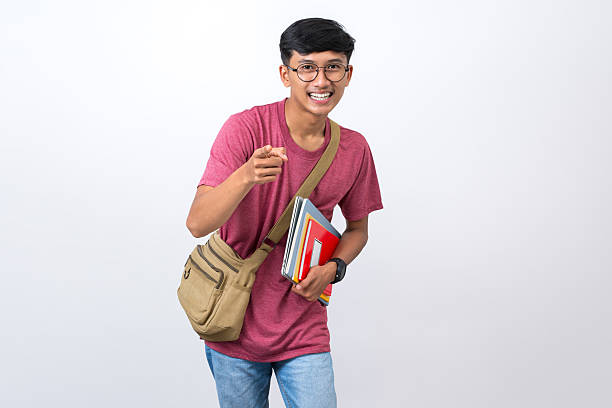 istock Young student pointing finger to the side isolated on white background. pointing to copy space 2232769117