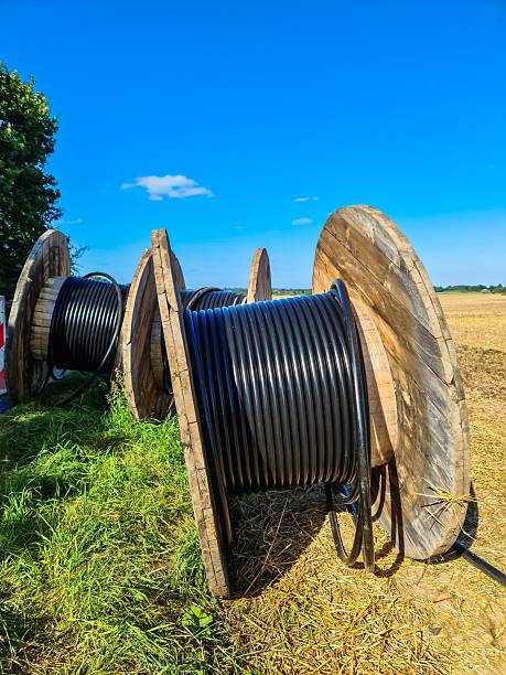 istock Wooden cable drums storing electric cables in a field under blue sky 2232773344