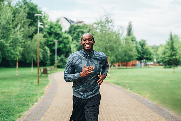 istock Smiling man jogging outdoors in the park. 2232773426