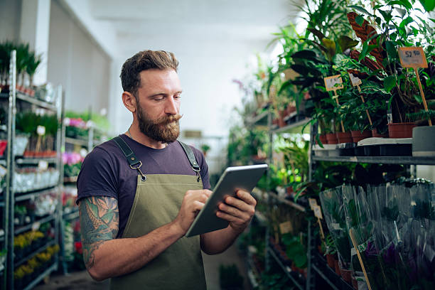 istock Bearded man using digital tablet and working in Flower store. 2232775335