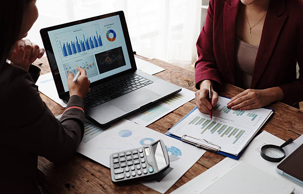 istock Two businesswomen are collaborating on a project, analyzing financial data displayed on a laptop screen and printed documents 2232781247