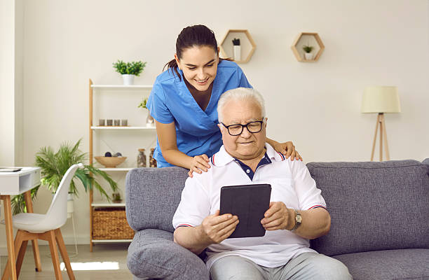 istock Nurse or caregiver helping happy retired senior man to use modern tablet computer 2232781496