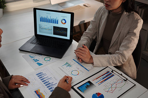istock Professional women reviewing financial analytics, comparing laptop data and printed reports for strategic investment planning 2232781583