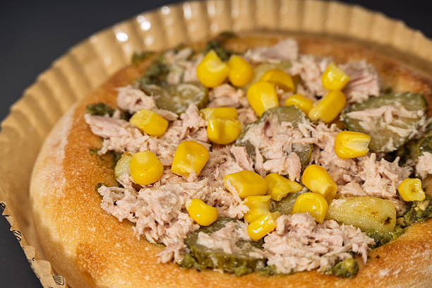 Tuna and Corn Pizza with Pickles and Herbs on a Golden Crust