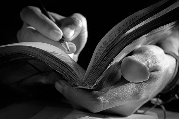 istock Close Up of Hand Writing with Pencil on Notebook in Black and White 2232788655