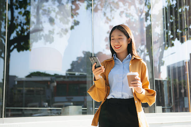 istock Young professional businesswoman smiling while talking on the phone outdoors, reflecting communication, confidence, and modern corporate lifestyle. 2232792830