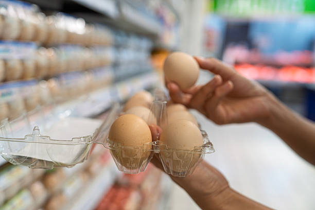istock Person selecting fresh eggs in supermarket aisle 2232799057