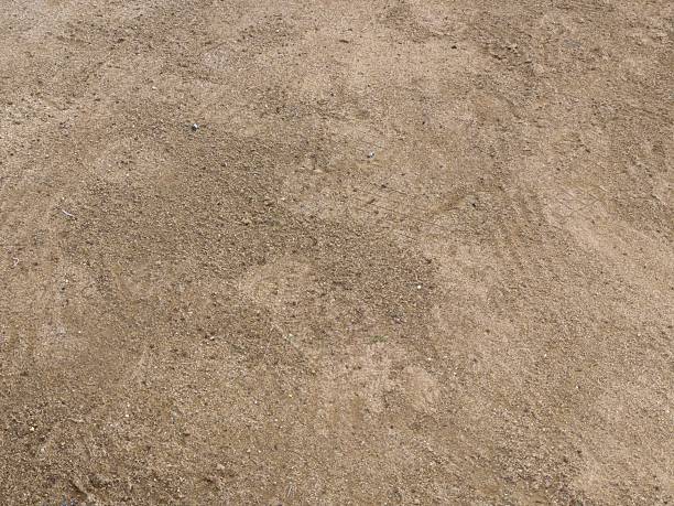 istock Close-up View of Natural Sandy Ground with Small Pebbles and Subtle Tracks 2232803585
