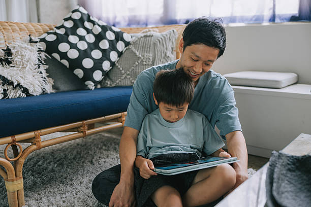 istock Japanese father and son using digital tablet together at home 2232805117