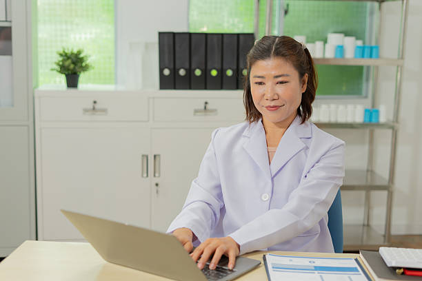 istock Asian female doctor working on laptop in modern office, professional and focused expression 2232808505