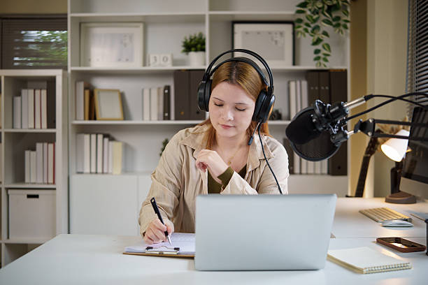 istock Podcast host  taking notes while recording a podcast at home with professional microphone. 2232809433