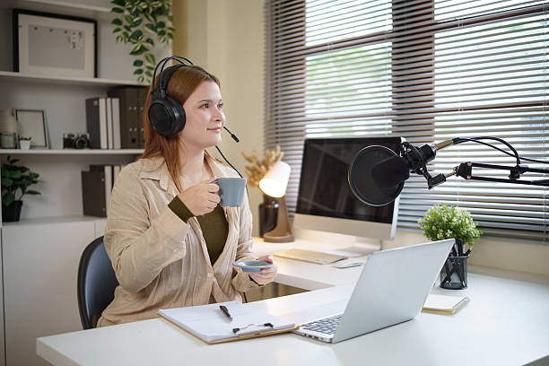istock Podcast creator in headphones recording content with a professional microphone setup. 2232809437