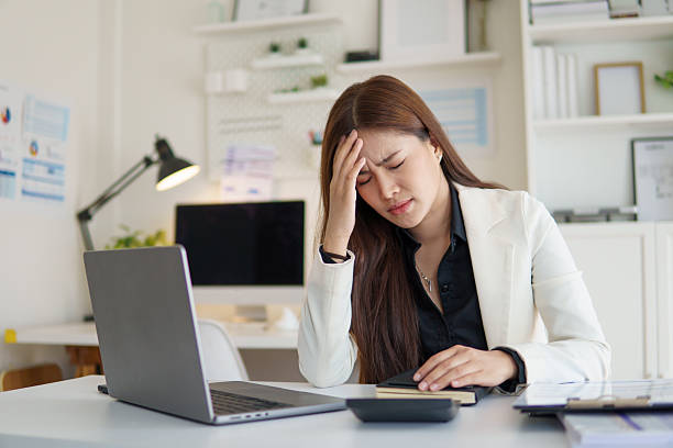 istock Stressed businesswoman holding her head while working at office desk. 2232809720