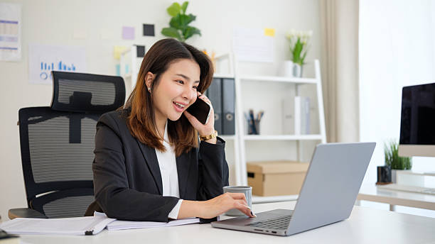 istock Confident female entrepreneur talking on the phone while working with laptop at office desk. 2232809772