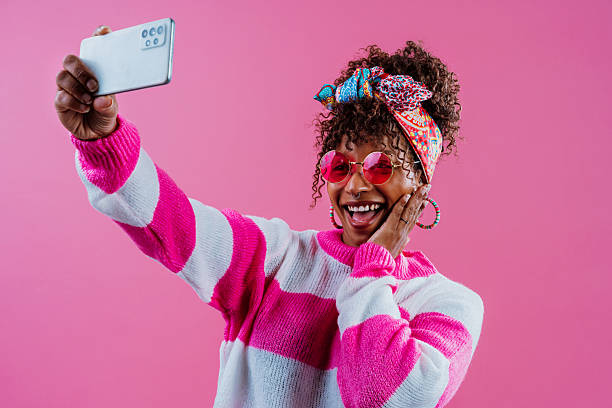 istock Enthusiastic influencer taking a selfie with smartphone on pink 2232810606