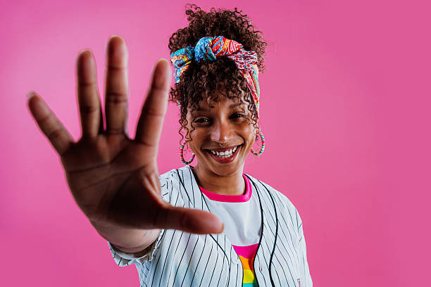 istock Cheerful young woman showing open hand on pink background 2232811341