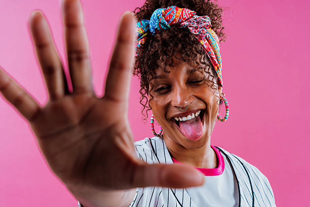 istock Cheerful young woman showing open hand on pink background 2232811358