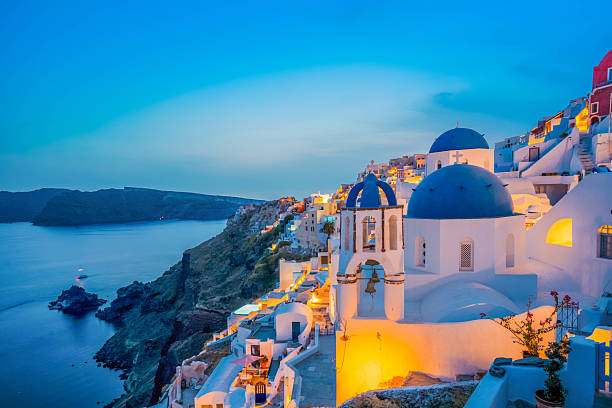 traditional greek village Oia of Santorini, with blue domes of churches and village roofs at night, Greece