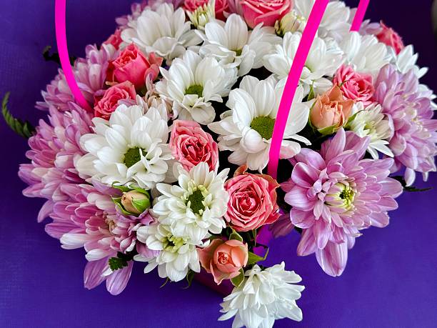 Florist with beautiful bouquet in box on green background, closeup. Space for text