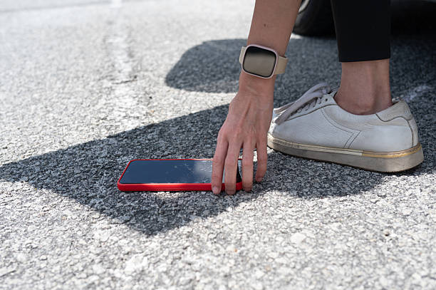 istock Retrieving a Dropped Phone Beside the Car 2232816248