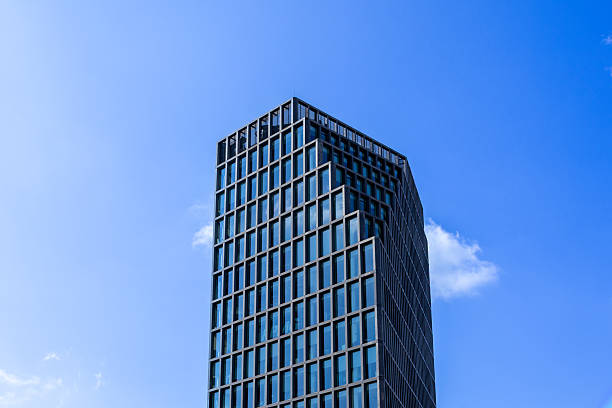 istock Impressive modern high-rise building with a sleek glass facade soaring into a vibrant blue sky, embodying corporate ambition and urban development 2232818656