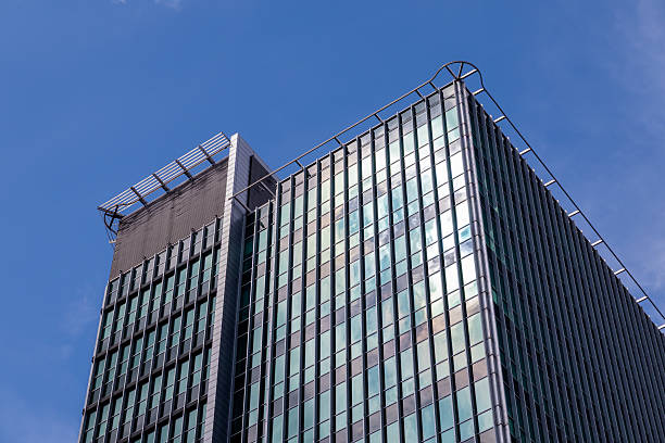 istock Modern high-rise office building, its reflective glass facade gleaming under a bright blue sky, represents urban business and architectural progress 2232818742