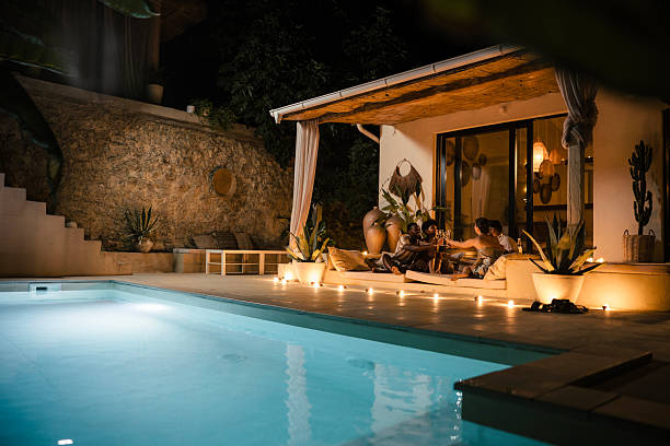 istock Two Couples Enjoying Wine and Conversation on Terrace at Night 2232829075