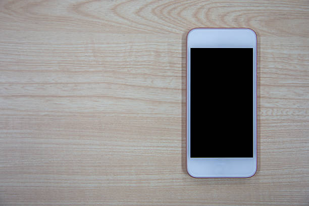 istock Wireless smartphone with blank screen on a wooden background, a digital device for communication 2232843384