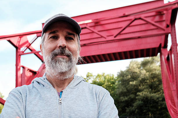 istock Portrait of a bearded engineer smiling with red bridge in background 2232846954