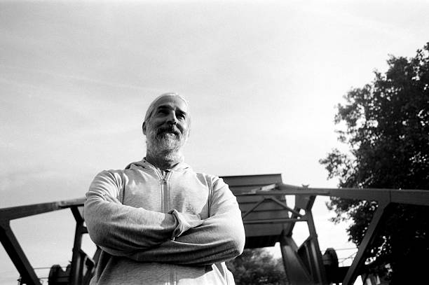 istock Confident mature man with folded arms posing under a bridge in black and white 2232847953