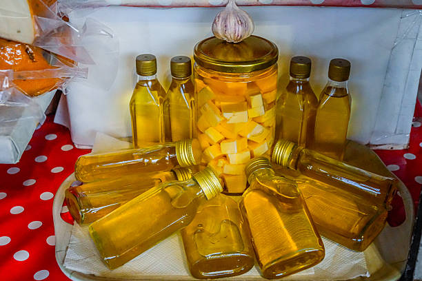 Bottles of garlic-flavored olive oil displayed on a market stall, ready for sale. Traditional Mediterranean product.