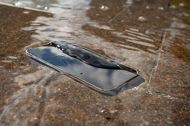 istock Broken smartphone submerged in water on stone surface 2232849217