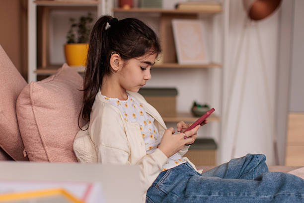 istock Young girl using smart phone in her room 2232852706