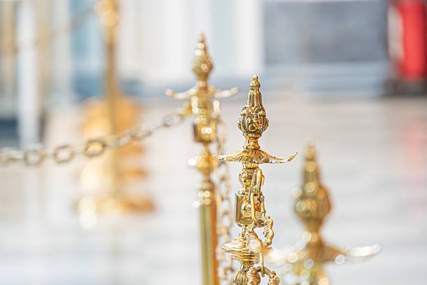 Luxurious setting with ornate metal handrails, intricately designed with decorative elements and golden hues Patterned floor in shades of white and gray Ornate wall feature hinted in the background