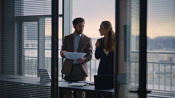 istock Business people reviewing documents having conversation architecture view office 2232855053