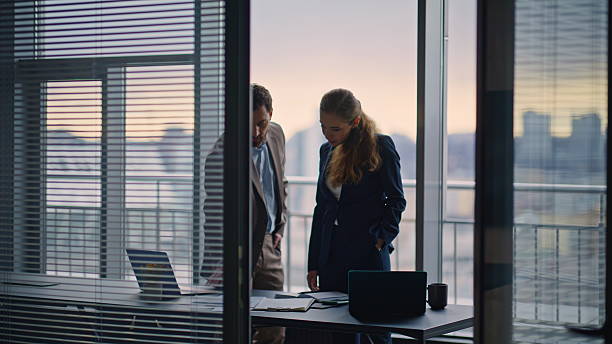 istock Confident partners discussing business partnership shaking hands office window 2232857310