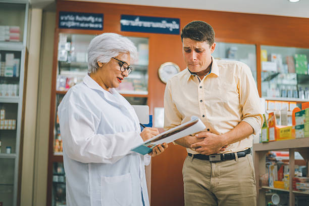 istock pharmacist is asking about a patient's condition in order to prescribe medication according to the patient's symptoms who come for prescription consultation in a modern pharmacy. 2232857351