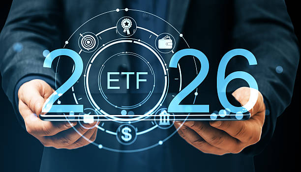 istock ETF investment concept for 2026 with digital interface symbols on transparent tablet held by person in dark suit on virtual background. 2232857534