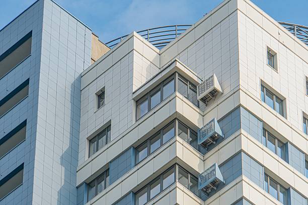 istock Modern gray residential building with clean, structured lines and contrasting white windows Adjacent structure partially visible in the background Clear sky backdrop, suggesting fair weather 2232858287