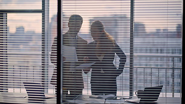 istock Couple businesspeople doing paperwork panoramic office. Colleagues silhouettes 2232858545