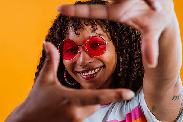 istock Young woman framing face with hands and smiling at camera 2232858654