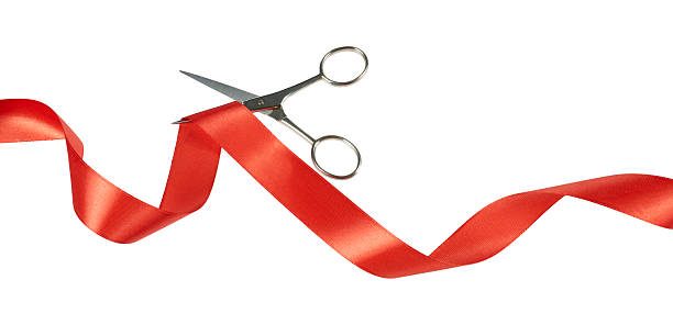 istock scissors cutting red ribbon band isolated on white 2232858761