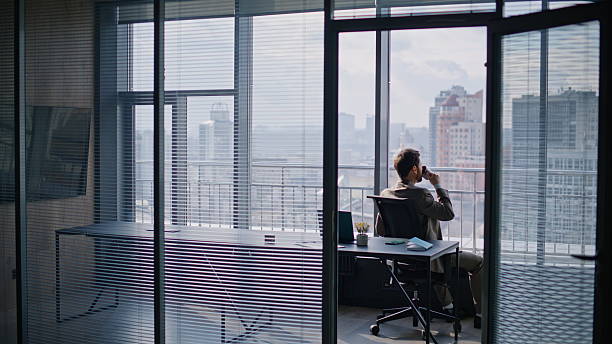 Successful businessman drinking coffee sitting window luxurious private office