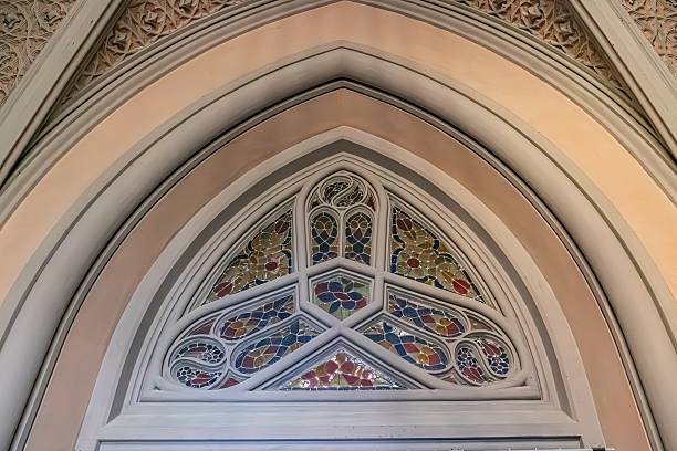 istock Old Gothic church interior, arched ceiling with geometric pattern, stonewood walls, decorative tiles, stained glass windows with vibrant colors, religious symbolism 2232859118